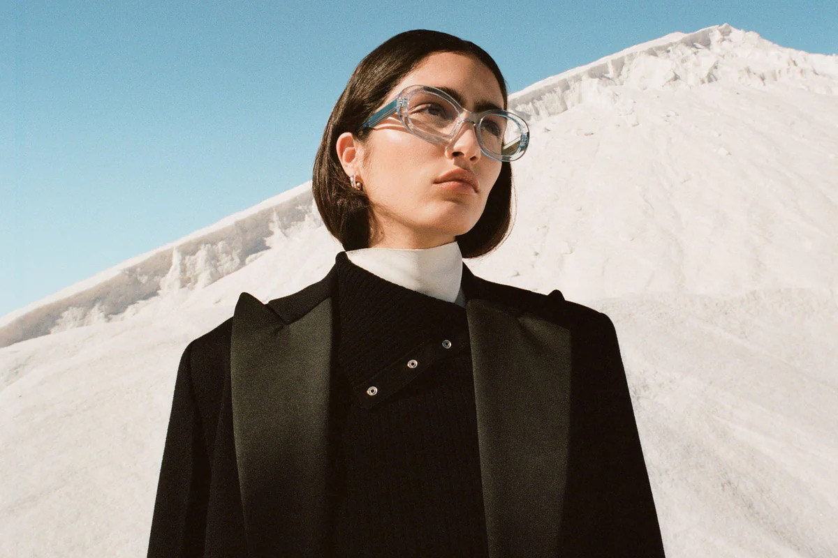Portrait d’une femme portant des lunettes Jimmy Fairly dans un décor naturel, illustrant le positionnement mode premium de la marque.